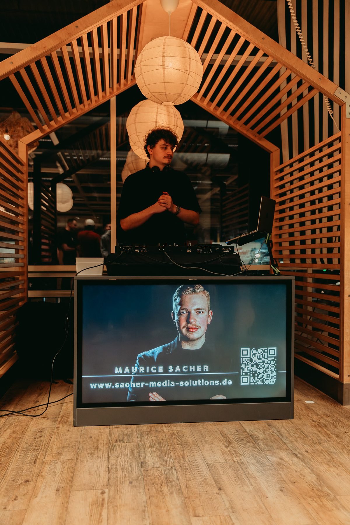 Aufgebauter Screen mit Branding von Sacher Media Solutions bei einer Veranstaltung
