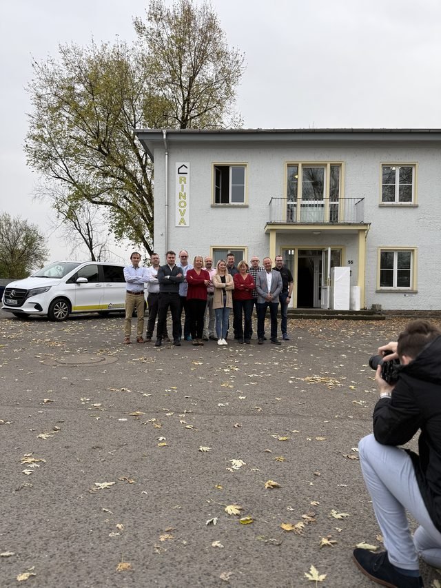 Teamfoto vor einem Firmengebäude